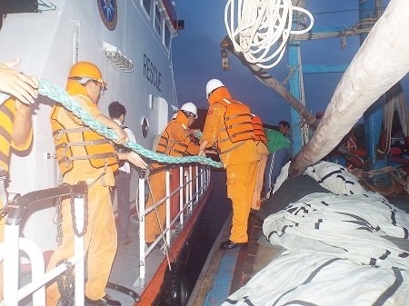 Ngư dân trên tàu cá Bình Định và thủy thủ tàu cứu nạn gia cố dây thừng sau khi cập cảng Nha Trang.