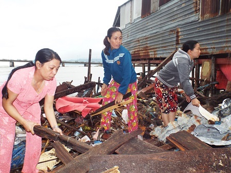 Người dân nhặt nhạnh đồ đạc còn xót lại trên đống đổ nát sau khi nhà sập.