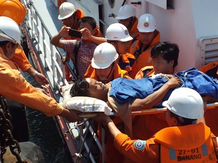 Đưa ngư dân Lương từ tàu SAR27-01 lên bờ cấp cứu.