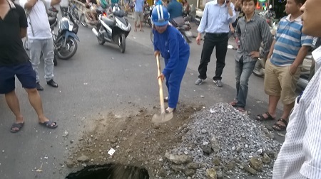 Hà Nội: Lại xuất hiện “hố tử thần” ở đường Đại Cồ Việt - 6 Tạm thời xử lý sự cố bằng cách đỗ lớp đất đá xuống hố tử thần.