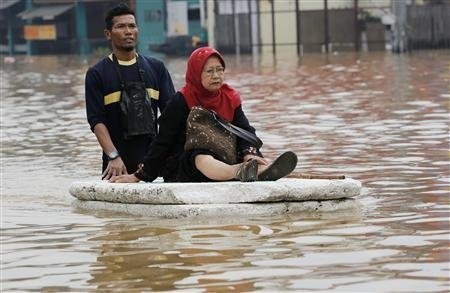 Người và xe bì bõm trong nước lũ ở thủ đô Jakarta - 3 Thuyền, phao, tấm xốp… tất cả đều được trưng dụng (Ảnh: Reuters)