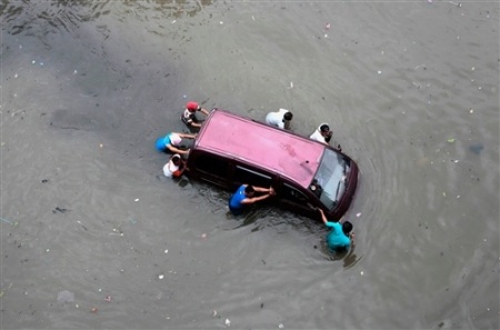 Người và xe bì bõm trong nước lũ ở thủ đô Jakarta - 9 ... hoặc phải cần rất nhiều người trợ giúp (Ảnh: Reuters)