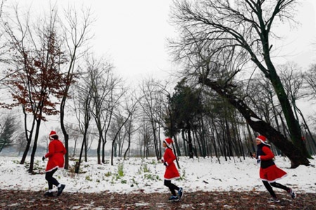 Hình ảnh thú vị về cuộc chay đua của các ông già Noel trên thế giới - 11 Các ông già Noel chạy trong tuyết ở Mogosoaia, gần Bucharest, Romania.