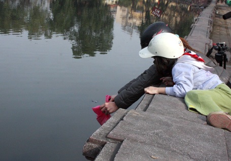 Các em bé đi theo bố mẹ đến nơi ngập rác