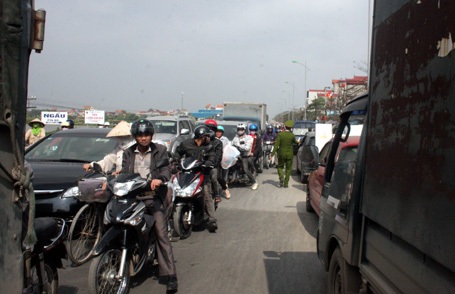 Xe máy len lỏi qua ô tô