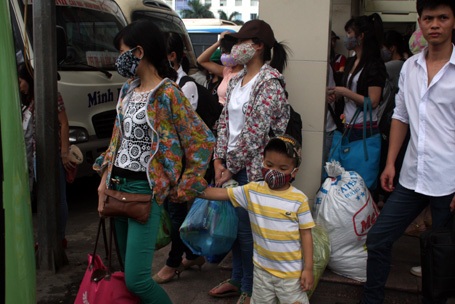 Các em nhỏ, uể oải đợi xe cùng người thân.