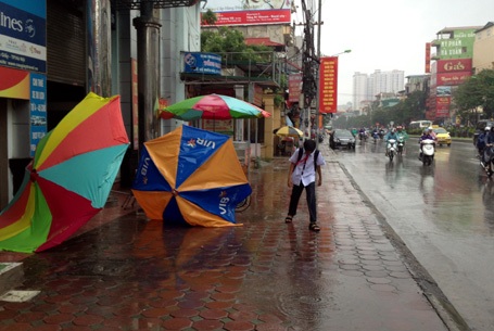 Gió lớn làm bật tung ô dù, biển hiệu trên các tuyến phố ở Hà Nội