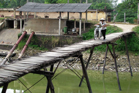 Cây cầu dài hàng chục mét được làm bằng vài thanh sắt, gỗ mục