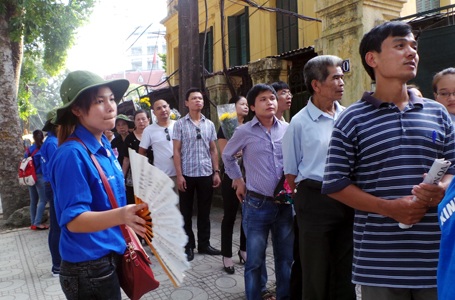 Sinh viên tình nguyên quạt cho dòng người đang kiên nhẫn xếp hàng chờ vào viếng Đại tướng