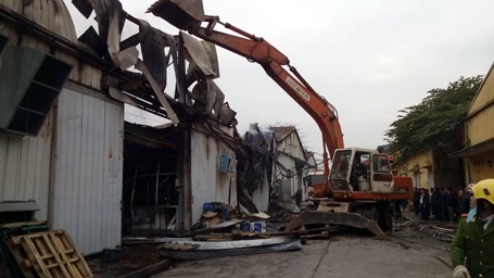 Hiện trường đổ nát sau đám cháy lớn tại Hà Đông - 5 Để phòng ngừa lửa bùng phát trở lại, lực lượng chức năng điều động máy xúc đến phá dỡ nhà kho