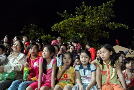 Các em nhỏ cùng người thân trong gia đình đi xem chương trình nghệ thuật đặc biệt