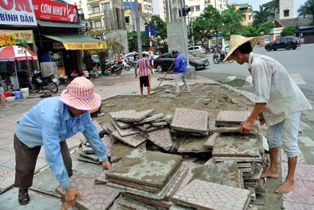 Công nhân đang cạy lớp gạch không đạt yêu cầu trên hè phố Ô Chợ Dừa - Hoàng Cầu