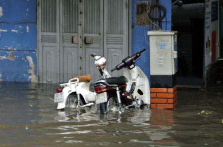 Hà Nội: Xe cộ “bì bõm” trên nhiều tuyến phố sau mưa - 4 Người dân bì bõm dắt xe vượt qua dòng nước sâu