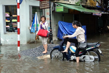 Hà Nội: Xe cộ “bì bõm” trên nhiều tuyến phố sau mưa - 5 Người dân bì bõm dắt xe vượt qua dòng nước sâu