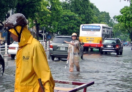 Hà Nội: Xe cộ “bì bõm” trên nhiều tuyến phố sau mưa - 11 Cảnh sát giao thông cố gắng điều tiết dòng phương tiện giải quyết tình trạng ùn tắc