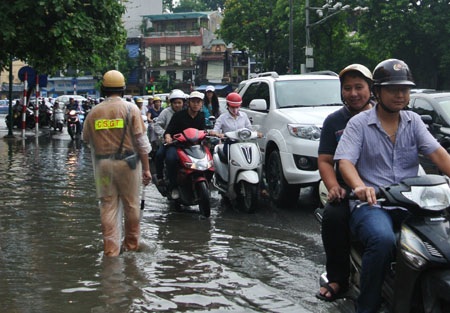 Hà Nội: Xe cộ “bì bõm” trên nhiều tuyến phố sau mưa - 13 Cảnh sát giao thông cố gắng điều tiết dòng phương tiện giải quyết tình trạng ùn tắc