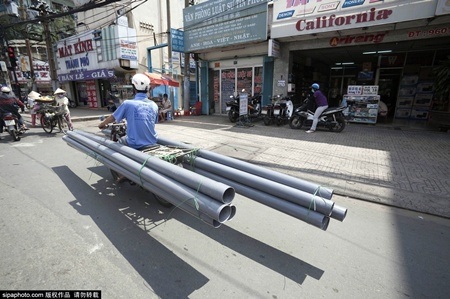 Trước đó, hình ảnh người đi xe máy chở quá trọng lượng, nhiều đồ cồng kềnh tại Việt