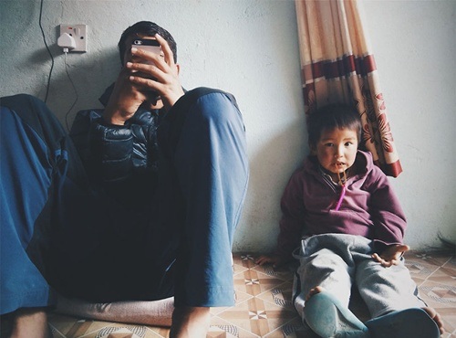 Cậu bé thổi bong bóng trước cửa nhà