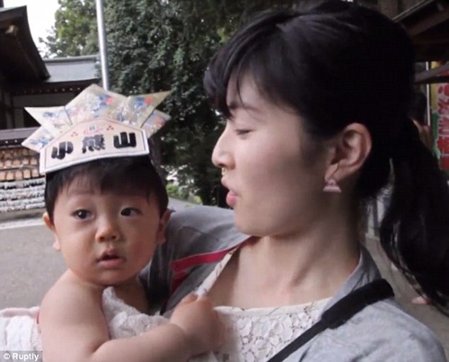 Lễ hội kỳ lạ, trẻ khóc càng to, bố mẹ càng... sướng - 5 Một bé trai mắt ngấn nước trong vòng tay mẹ