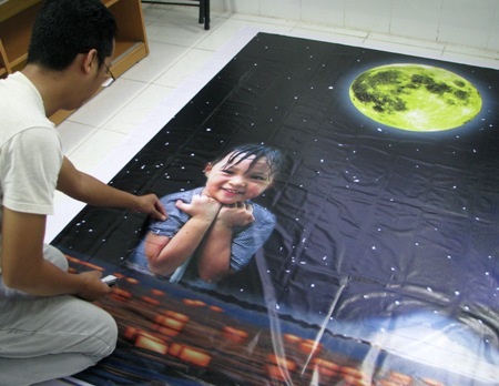 ...và bức tranh do 1.000 em thiếu nhi tham vẽ đang trong giai đoạn hoàn tất.