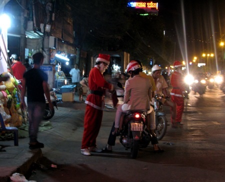 Có những ông già Noel khác đứng cả ra đường phát quà cho các em thiếu nhi.