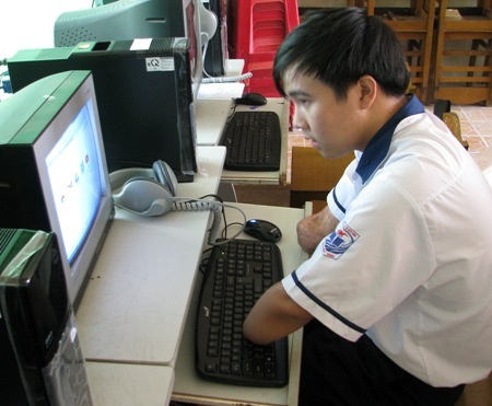 Sửng sốt cậu học trò viết chữ bằng chân - 4 Bằng hai cùi chỏ, Kiệt sử dụng máy vi tính khá thành thạo. (Ảnh: Huỳnh Hải)