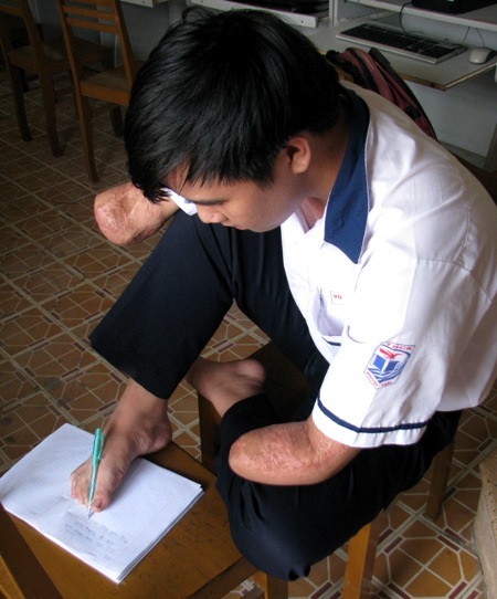 Sửng sốt cậu học trò viết chữ bằng chân - 3 Kiệt đang viết bài bằng chân sau một thời gian dài khổ luyện. (Ảnh: Huỳnh Hải)
