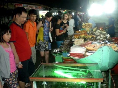 Du khách rất thích thú với kiểu ăn hải sản chỉ con nào làm con ấy ngay tại chợ.