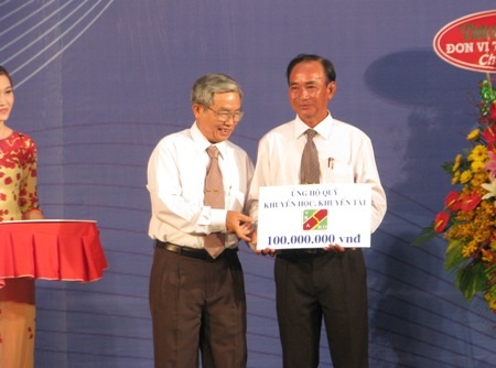 Đại diện Hội Khuyến học Cần Thơ (trái) tiếp nhận bảng tượng trưng ủng hộ quỹ khuyến học.