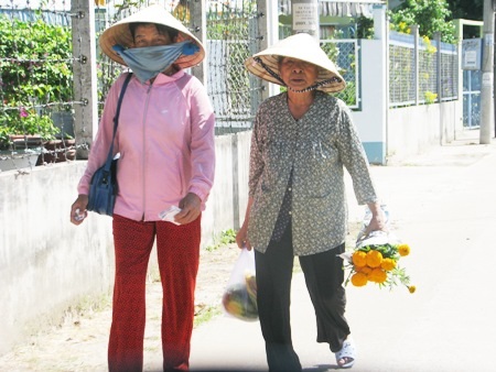 Một bà cụ mua hoa về cúng tiễn ông Táo về trời.