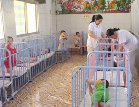 Nỗi lòng mấy chục năm nuôi con người khác - 1 Các chị em phụ nữ với công việc tại Trung tâm nuôi trẻ mồ côi.