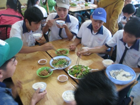 Các thí sinh hối hả dùng cơm miễn phí để kịp thời gian cho buổi thi chiều. (Ảnh: Huỳnh Hải)