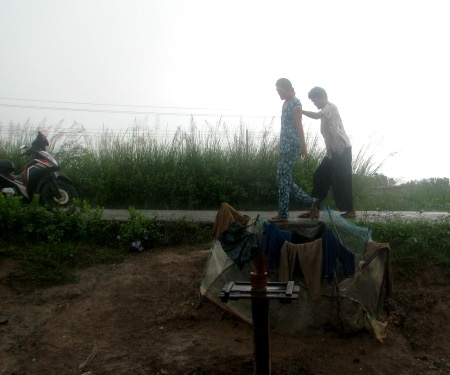 Ám ảnh nỗi khổ của một gia đình “khổng lồ” - 3 Hai mẹ con khổng lồ- bà Láng và con gái út - đi trên đê trước nhà.