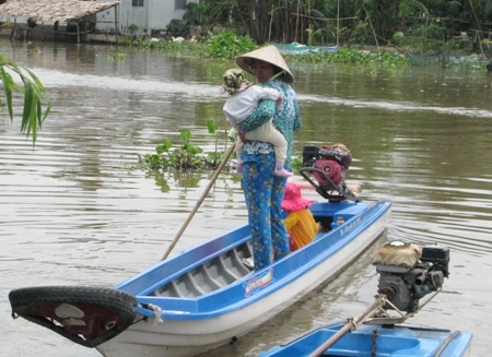 Nỗi khó khăn đến trường của học sinh tuyến dân cư "3 không" - 6 Tay bồng tay đón chống xuồng cùng con ra về sau một buổi học.