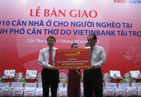 Lãnh đạo Vietinbank (trái) trao bảng tượng trưng số tiền xây 2.010 căn nhà ở cho người nghèo.