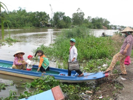 Nỗi khó khăn đến trường của học sinh tuyến dân cư "3 không" - 4 Học sinh tan học cùng xuống xuồng theo chân phụ huynh về nhà.