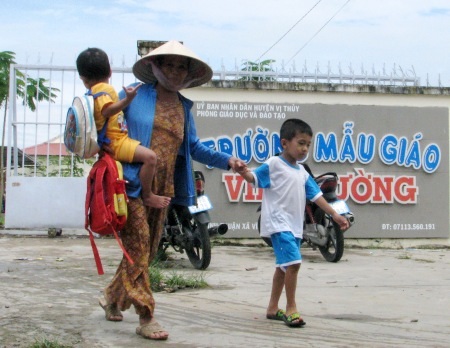 Nỗi khó khăn đến trường của học sinh tuyến dân cư "3 không" - 5 Cha mẹ bận đi làm ăn, các cháu được bà đưa đón đi học.