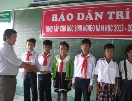 Thầy Trần Tứ Hải- Hiệu trưởng Trường Tiểu học Hộ Phòng B trao vở đến các em học sinh nghèo.