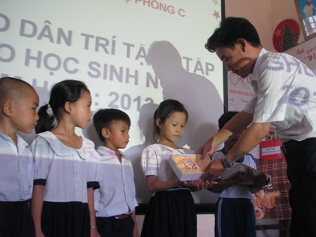 Thầy Nguyễn Phúc Lộng- Hiệu trưởng Trường Tiểu học Hộ Phòng C trao vở cho học sinh.