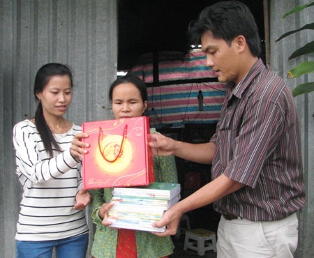 Đại diện chính quyền địa phương trao tập và bánh trung thu cho chị Hằng. (Ảnh: Huỳnh Hải)