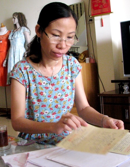 Người phụ nữ hai lần chiến thắng “tử thần” ung thư - 1 Chị Kim Thư bồi hồi xem lại những giấy tờ liên quan đến hai căn bệnh ung thư của mình.