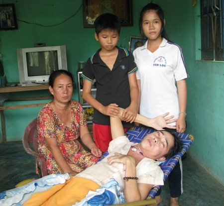 Hơn 27 triệu đồng đến với gia đình "bố nằm liệt giường, hai con nghỉ học phụ mẹ mưu sinh" - 1 Hai chị em Khánh Ngân, Khánh Dương bên bà ngoại và người cha nằm liệt giường.