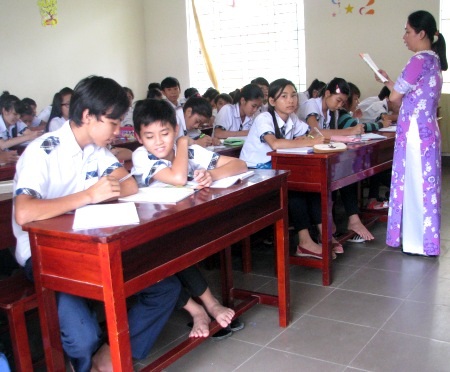 Học sinh cấp 2 khom lưng ngồi bàn ghế dành cho cấp 1 - 2 Trong khi đó, số bàn ghế chuẩn thì số lượng hạn chế.