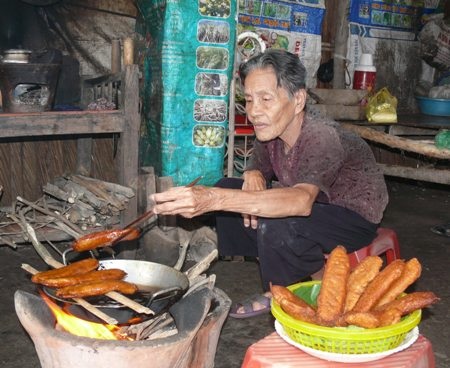 Cụ Xạ đang chiên bánh bán lấy tiền nuôi cháu ăn học.