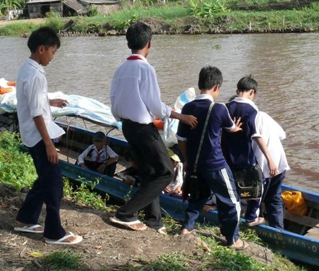 Chiếc đò nhân ái đưa học sinh nghèo đến trường - 2 Các em học sinh xuống đò đi học.