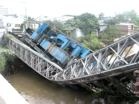 “Hoảng hồn” với hình ảnh cầu gãy gập vì xe tải - 2 Một bên cầu tạm cầu Vồng gãy gập hẳn xuống lòng sông dưới sức nặng của xe tải có tải trọng 60 tấn.