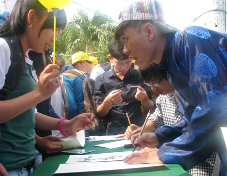 Sôi nổi học sinh xin chữ lấy may mắn thi cử - 2 Học sinh trao đổi với ông đồ để xin chữ theo ý muốn .