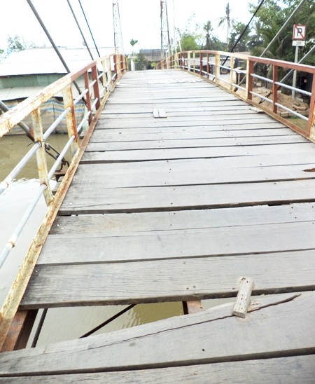 Ván nền cầu bị xê dịch, người dân phải dùng ván nhỏ đóng kềm lại cho chắc.