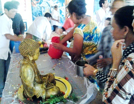 Nghi thức tắm Phật, cầu siêu độc đáo của người Khmer - 1 Người dân cùng tắm Phật bằng nước hoa thơm.