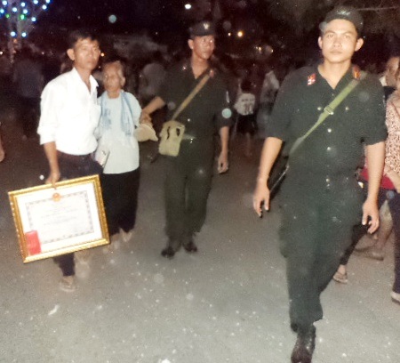 Hình ảnh 2 chiến sĩ cảnh sát Sóc Trăng giúp mẹ Việt Nam anh hùng tại buổi lễ.